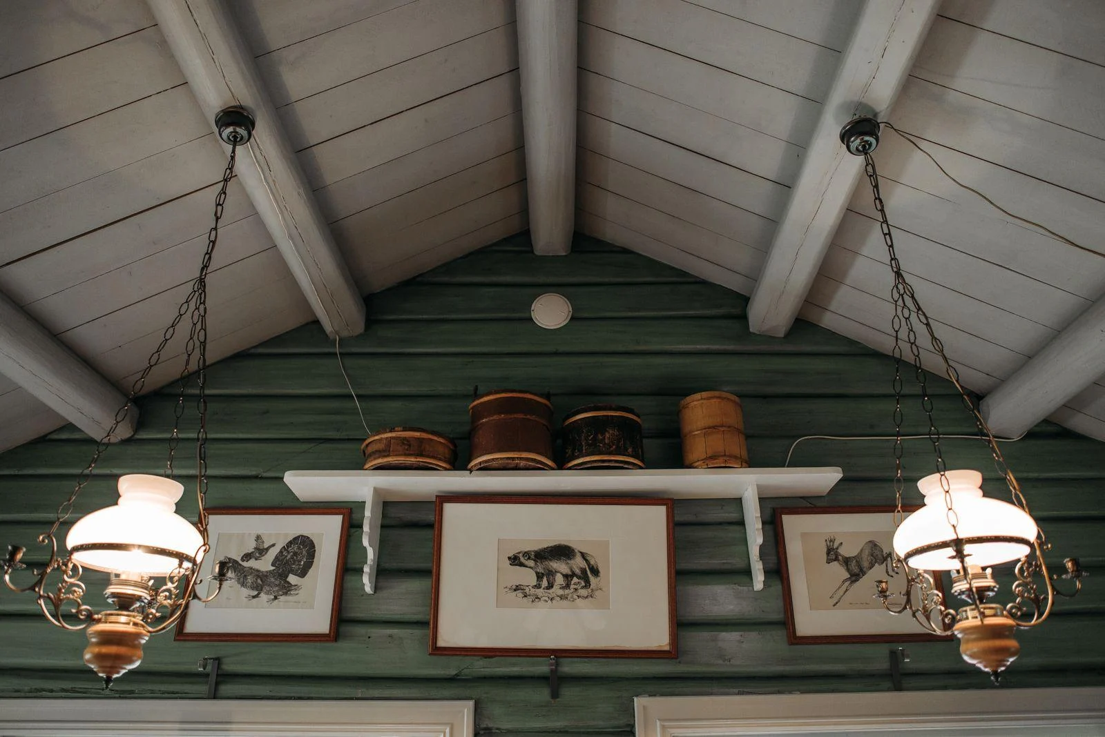Light mats and framed animal illustrations against deep green painted boards.