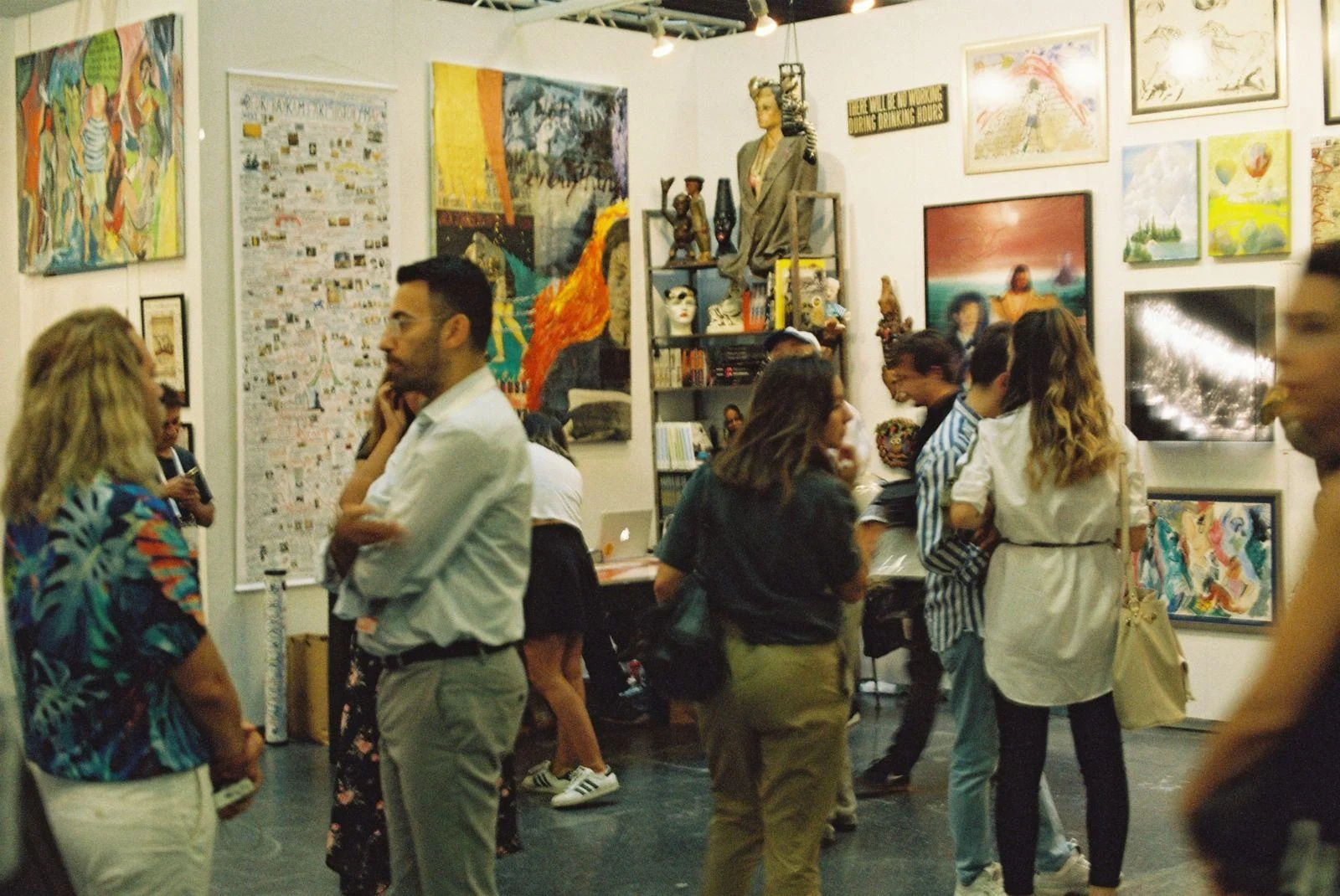 Visitors browsing artworks displayed at an art gallery.